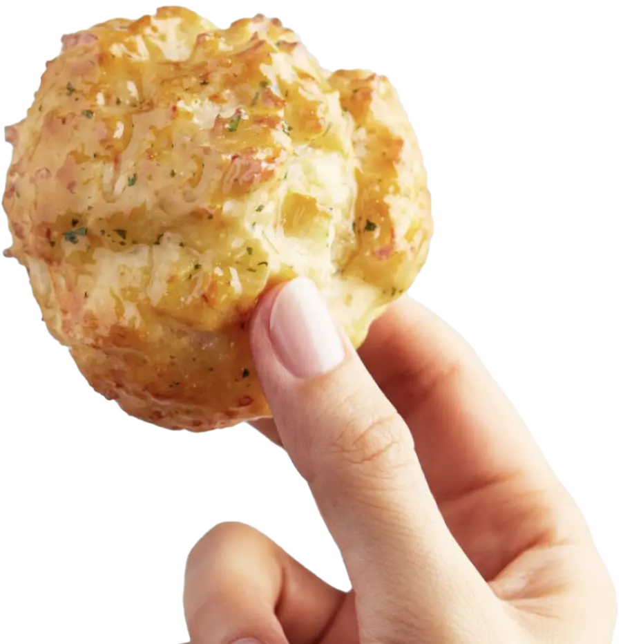 a hand holding a Cheddar Bay Biscuit®